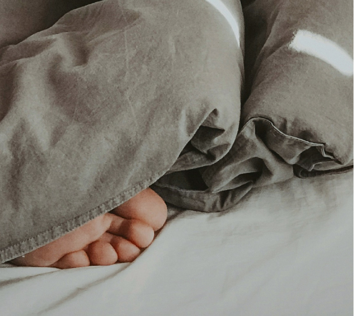 QuietOn 4 active noise-canceling earbuds helping a person fall asleep better by blocking disturbing noises for a calm, restful night.