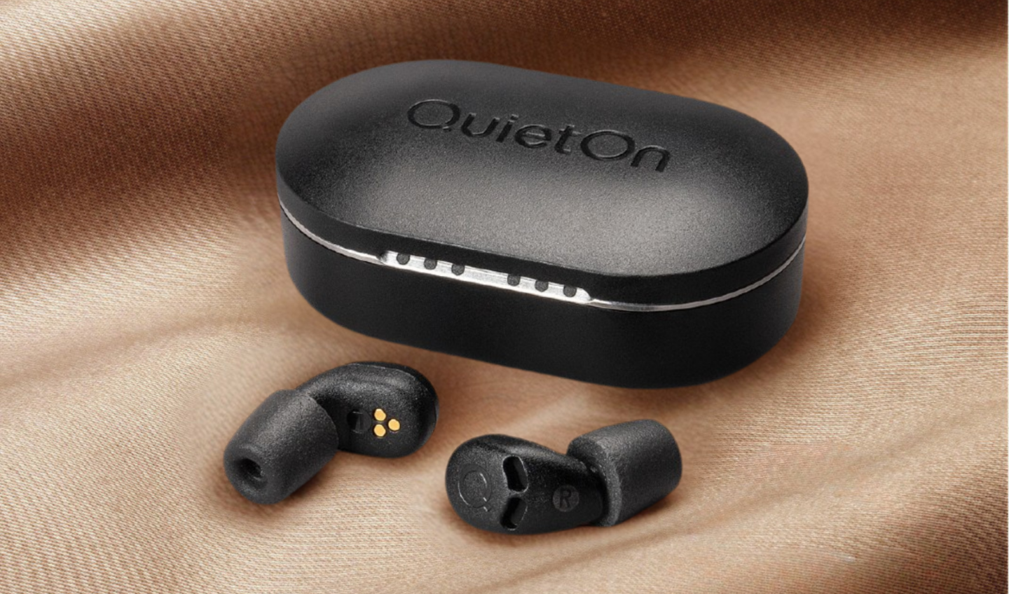 QuietOn 4 sleep earbuds and charging case on soft fabric — matte black ANC sleep earbuds with foam tips and compact carrying case